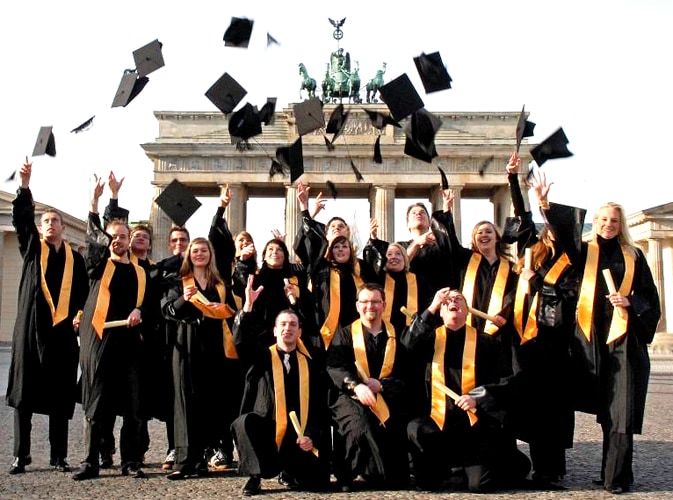 Graduates throwing their caps at the Brandenburg Gate in Berlin